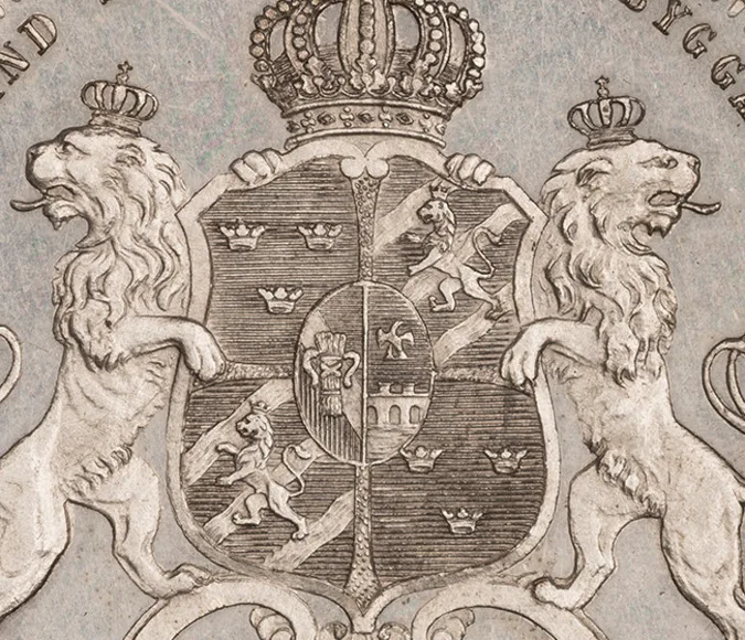 närbild på mynt som pryds av två lejon som står och håller i Sveriges riksvapen