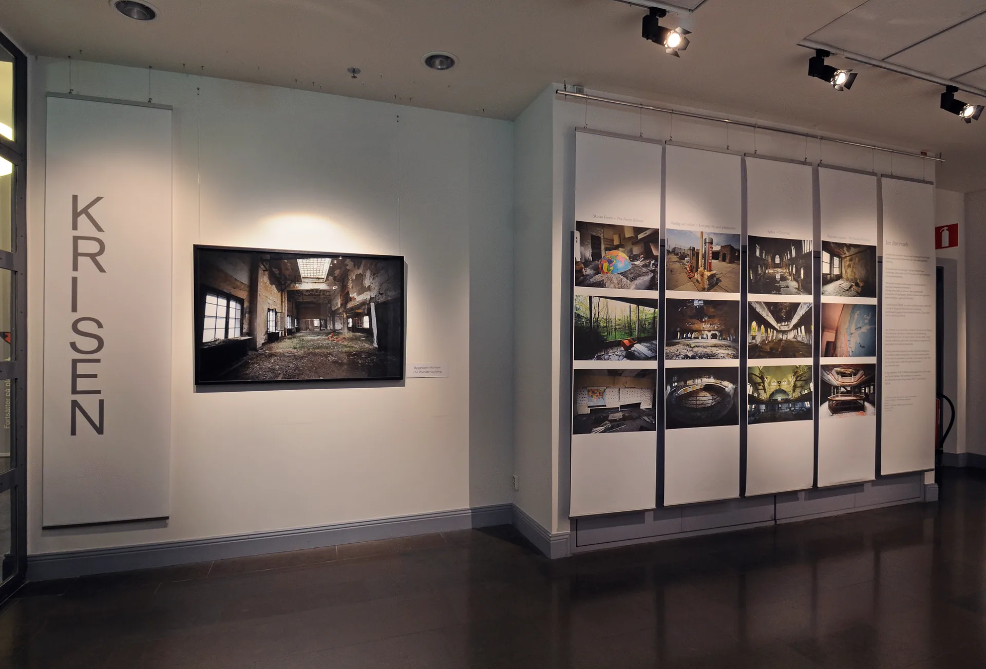 En vägg med fotografier från utställningen krisen