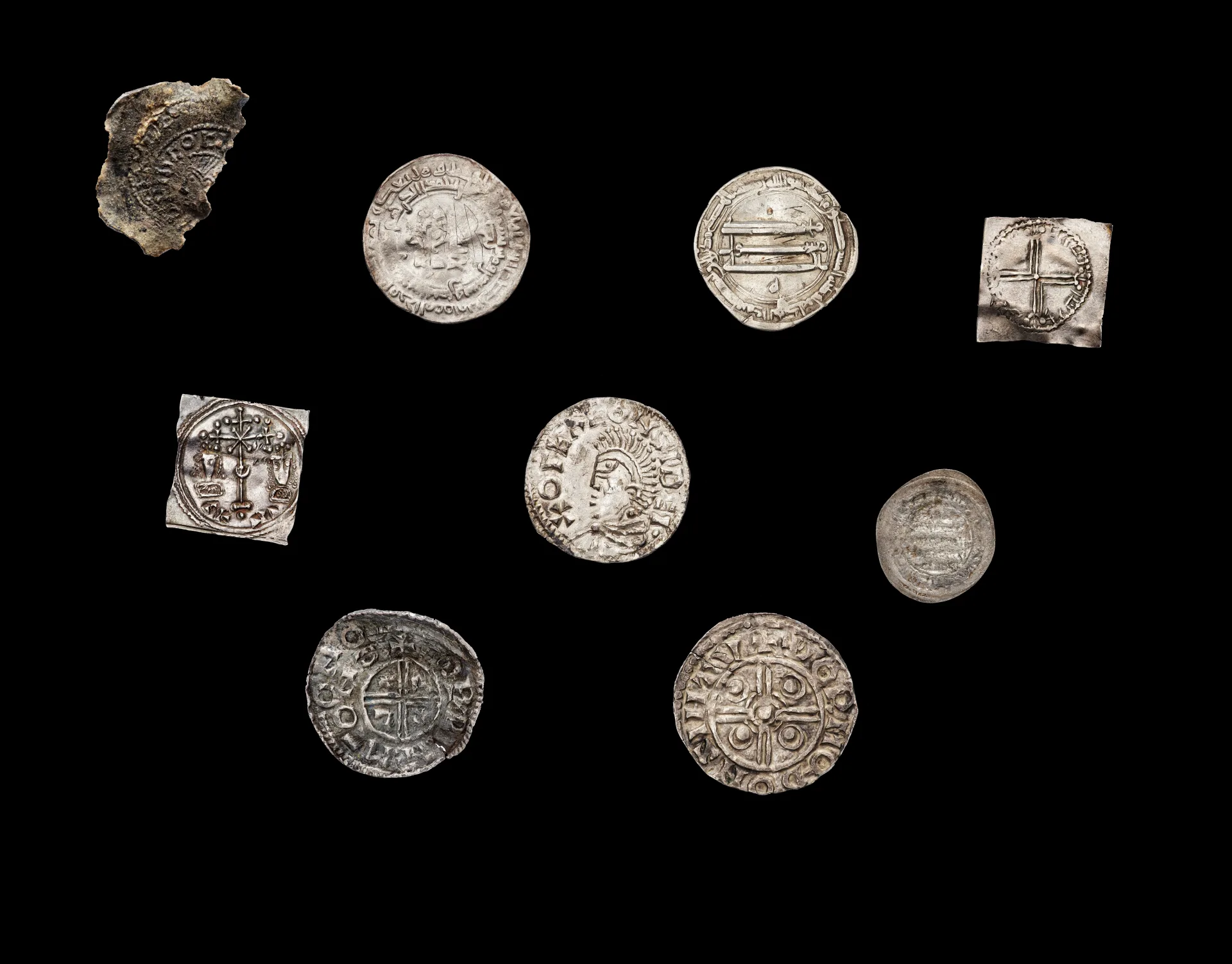 Mynt från vikingatiden mot svart bakgrund.