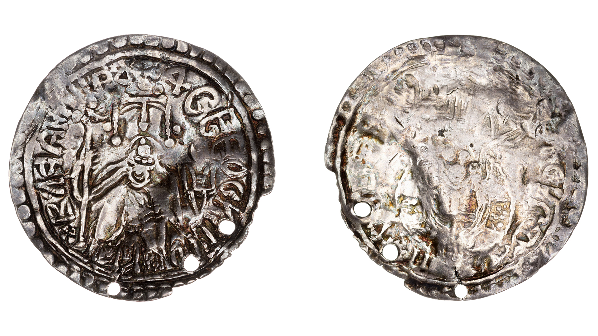 Silver coin, front and back. There are holes on the outside of the coin.