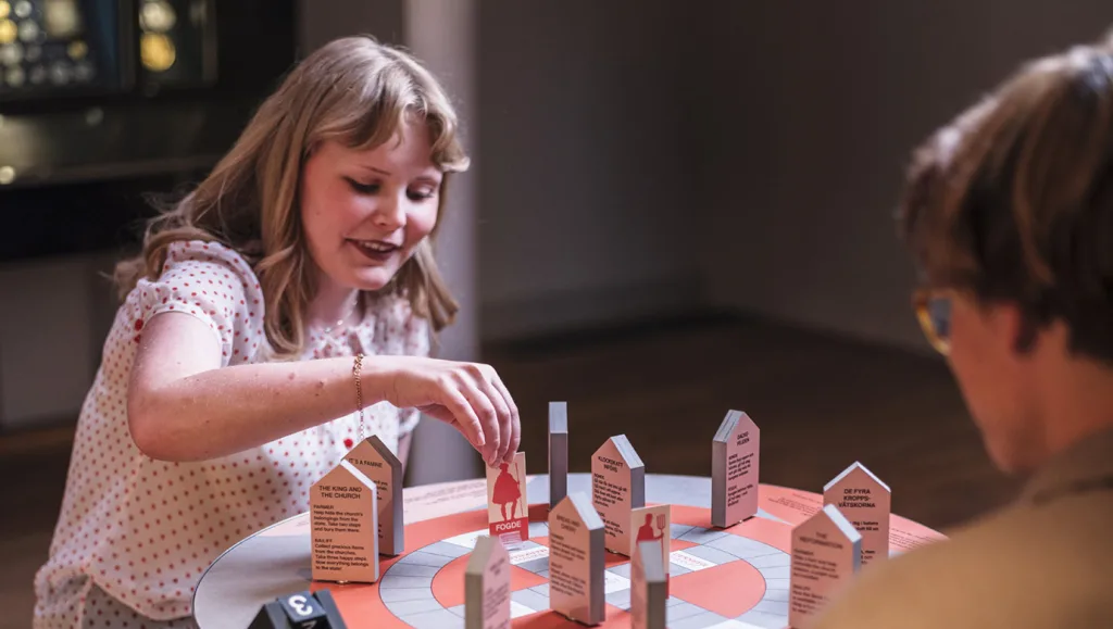 Besökare i museet som spelar i ett brädspel.