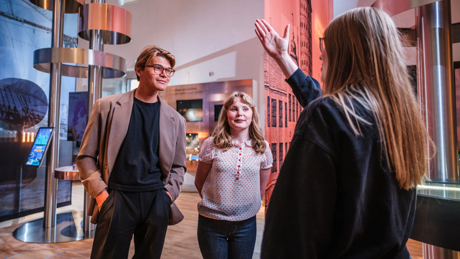 Två personer blir guidade av en museipedagog.