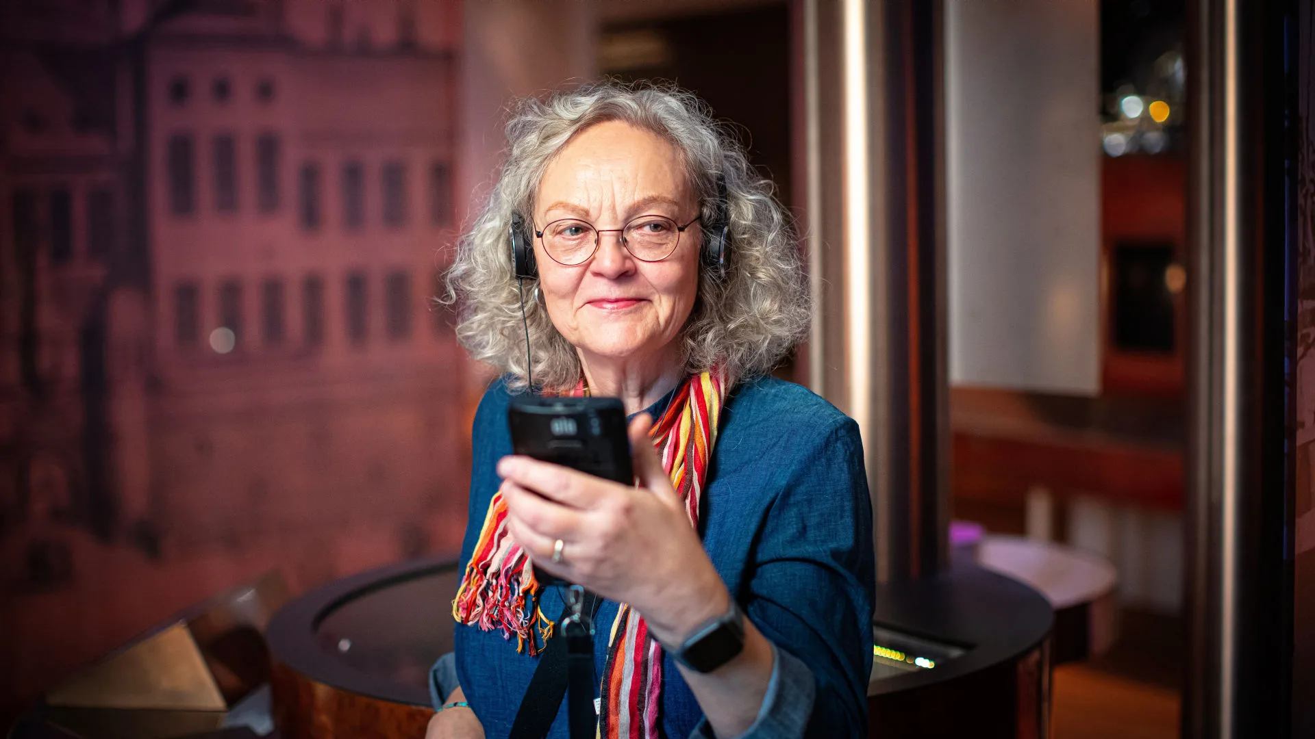 Image of a senior visitor listening to the museum's audio guide.