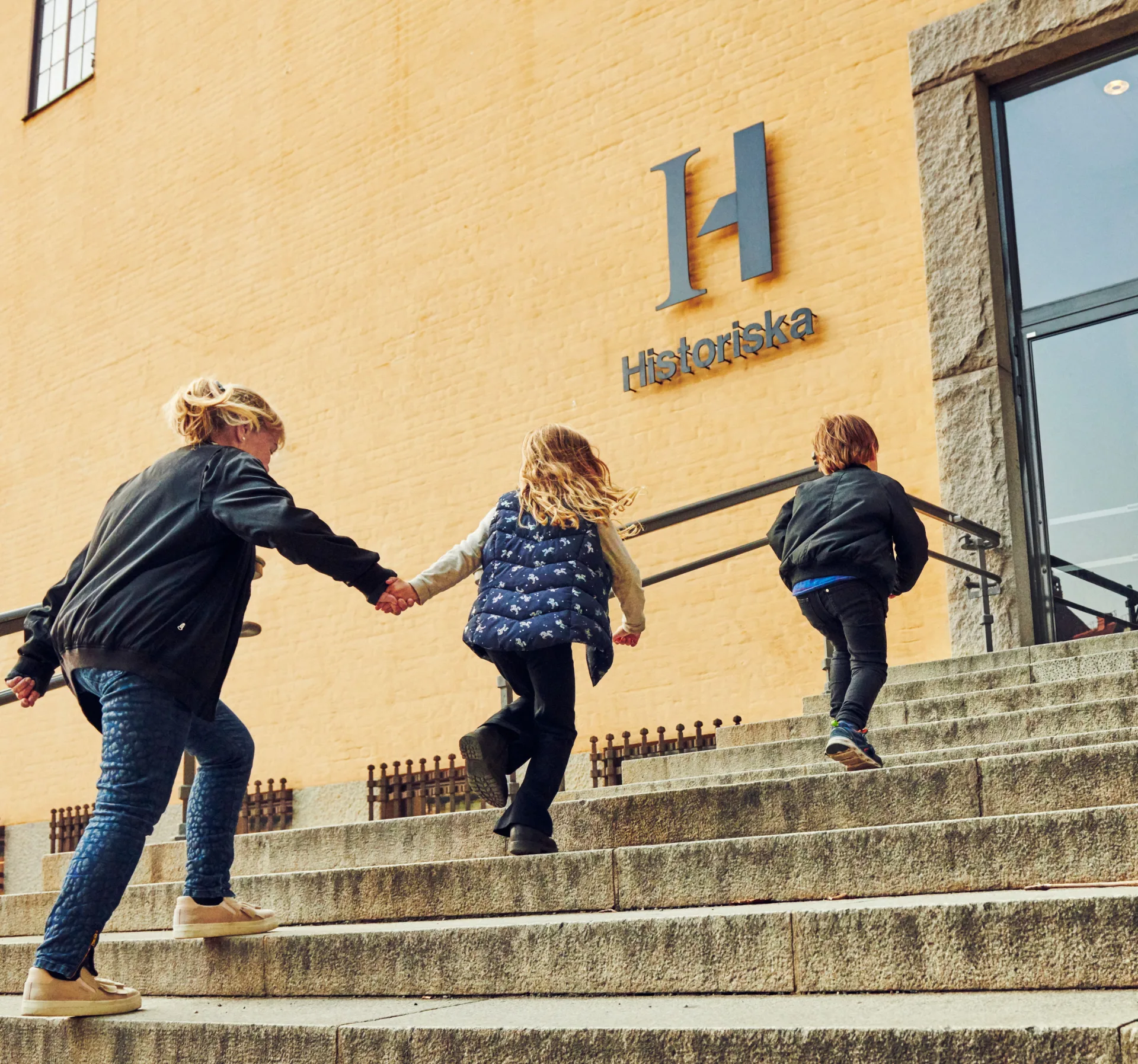 Photo of an adult visitor and two children looking at the Economy museums exhibition