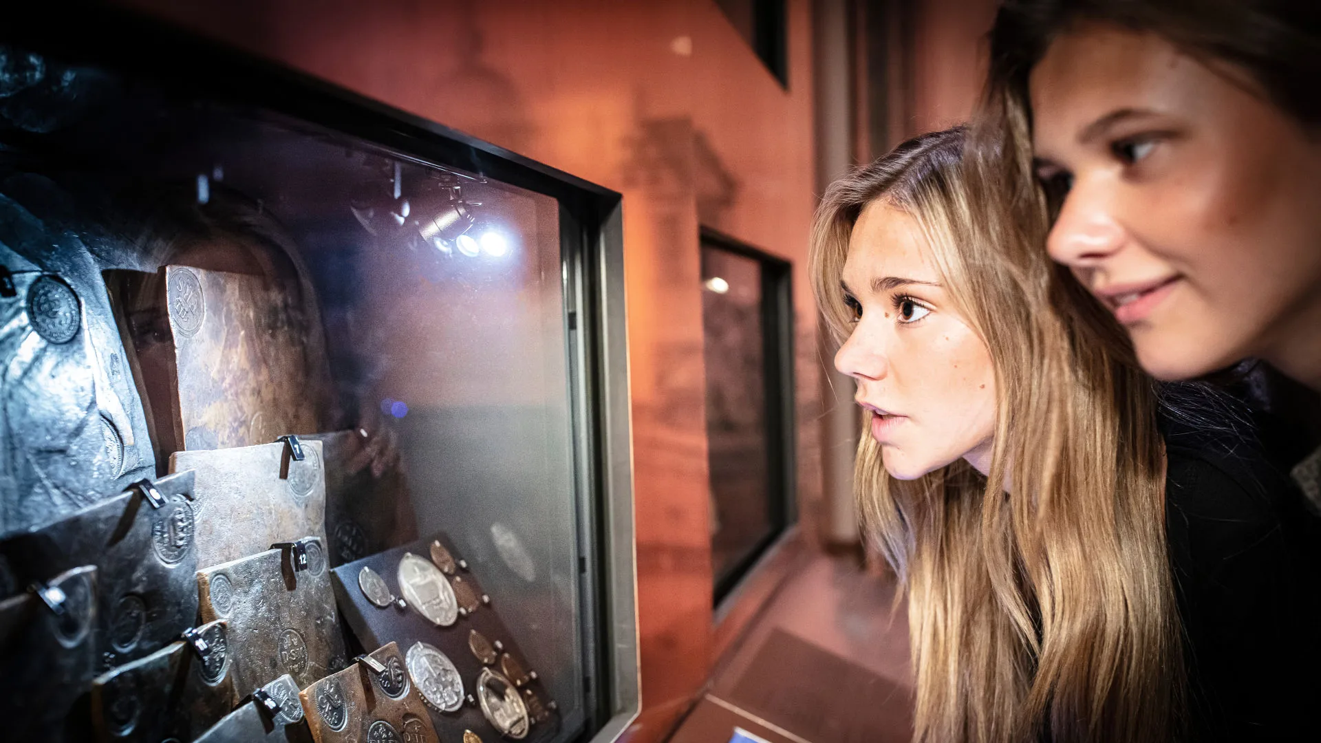 Skolelever tittar på gamla mynt i museets utställning