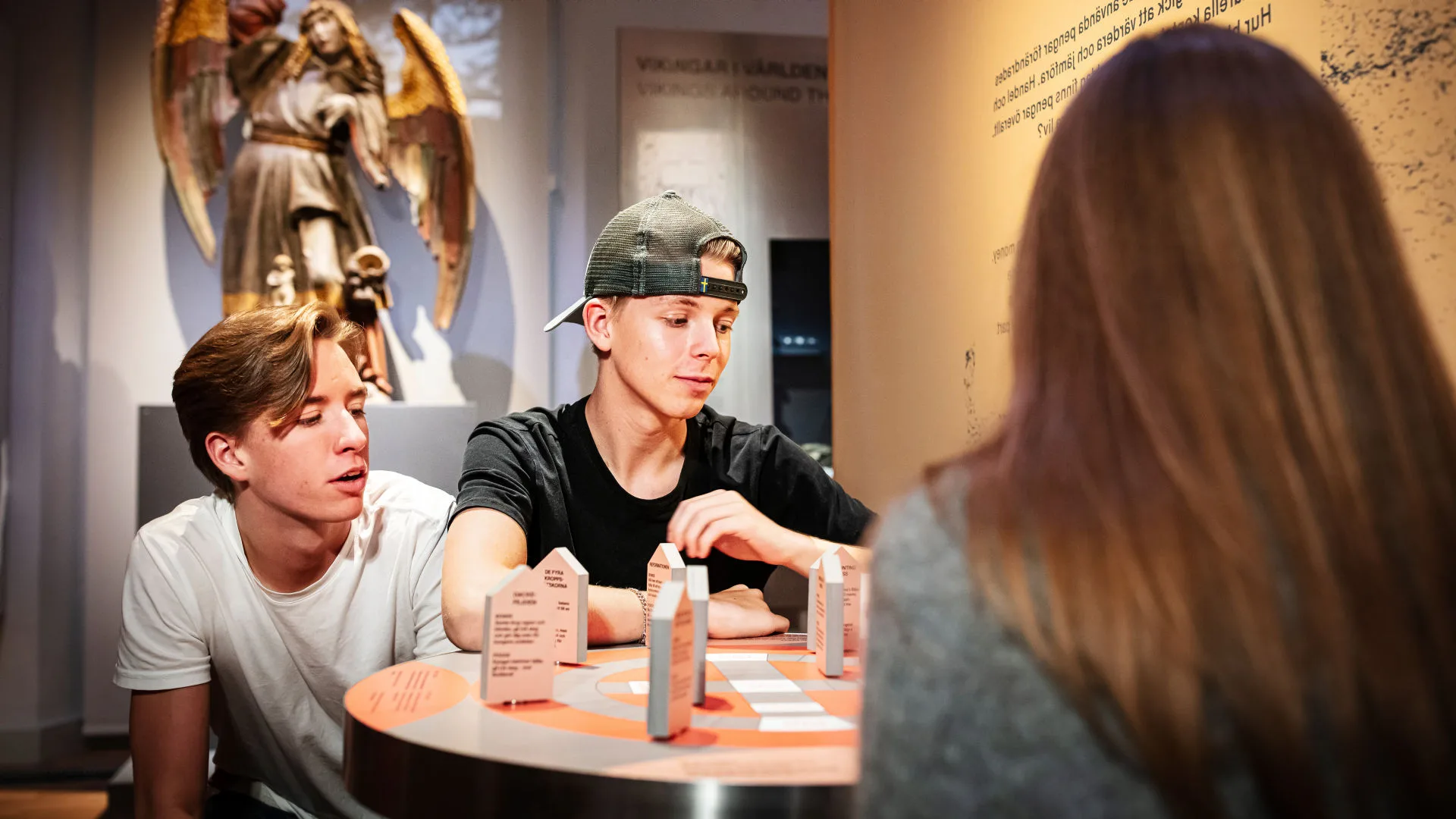 Ungdomar sitter och spelar ekonomispelet på museet