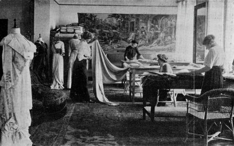 En syateljé med fyra kvinnor. Tre av kvinnorna arbetar, en håller upp ett tyg.