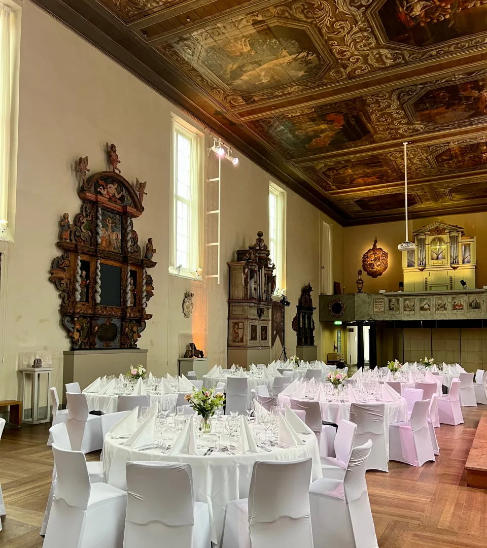 Runda bord med vita dukar i Barockhallen.