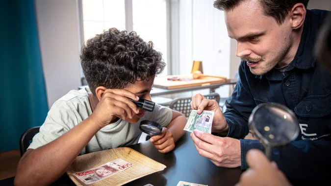 museum educator helping a kid discover bank notes